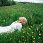 Blond woman lying in field